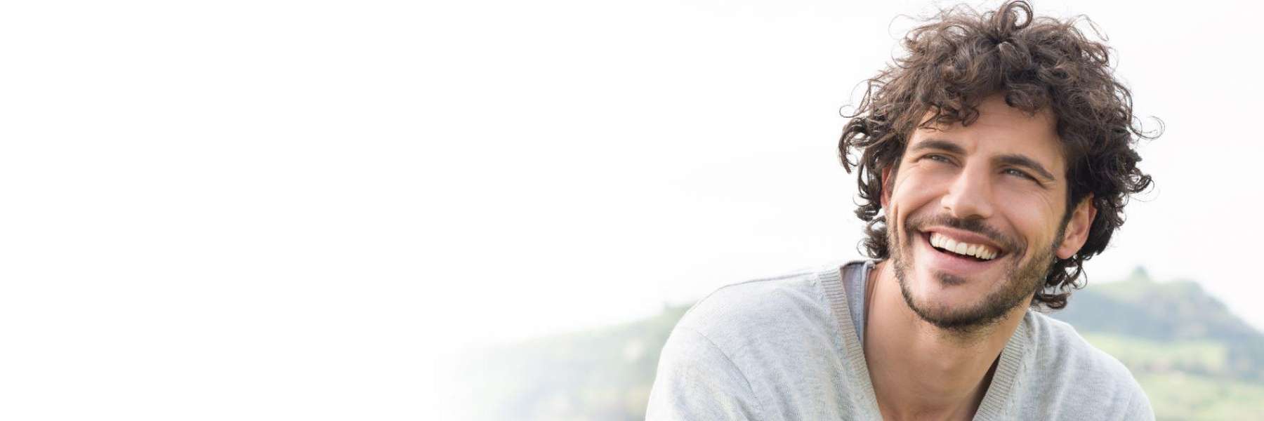 man with curly hair smiling